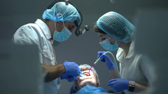 Side View Dental Assistant Removing Saliva with Sucking Tube As Doctor Injecting Anesthesia in Mouth alt