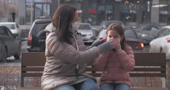 A Mother and Her Daughter Put Protective Masks on