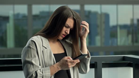 Young Woman with a Smartphone in Her Hands