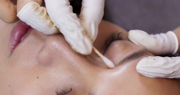 Young woman gets facial beauty procedure, microblading procedure alt