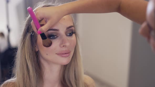 The Makeup Artist Applies the Powder to Finish Client's Makeup Slow Motion alt