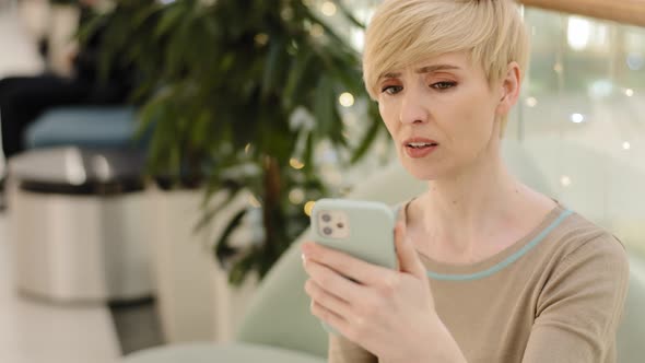 Stressed Nervous Adult Mature 40s Woman Looking at Cellphone Screen Feeling Frustrated Upset alt