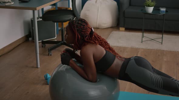 Athletic Slim Black Woman Stretching Abdominal Muscle While Sitting on Yoga Fitness Swiss Ball alt