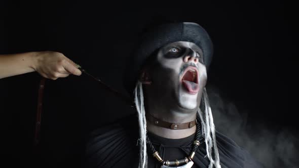 Sinister Man with Halloween Skeleton Makeup. Female Hand Grabs Collar of Guy and Pulls Him To Ground alt