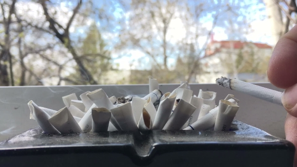 Man Smokes a Cigarette In An Ashtray And Extinguishes. 