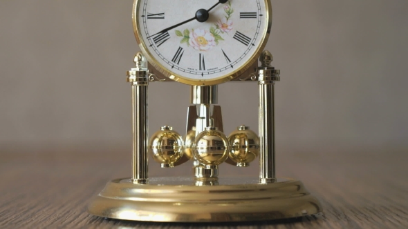 Clock With a Pendulum In a Form Of Rotating Balls