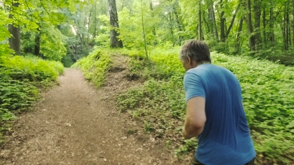 Adult Man Running Jogging Outdoors In a Forest Nature On a Forest Trail alt