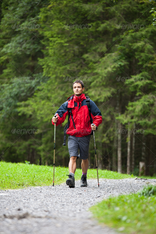 active handsome young man nordic walking/hiking in mountains, en - Stock Photo - Images