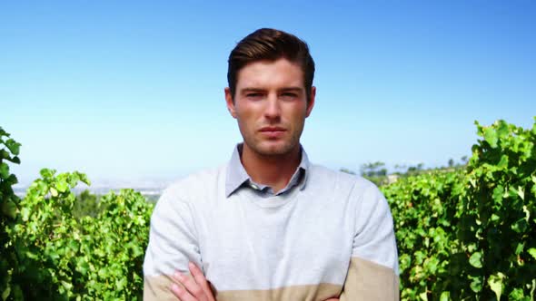 Portrait of man standing with arms crossed in vineyard alt