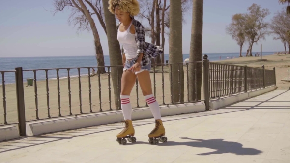 Woman Riding On Vintage Roller Skates. alt