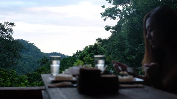 Blurred of a woman having dinner and looking a beautiful nature view