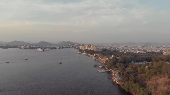 Wide Panoramic view of Pichola lake bank with Taj lake palace in the distance at sunset, Udaipur alt