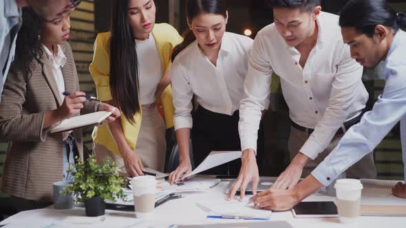 Asian young business people group have discussion meeting brainstorming and work at night in office. alt