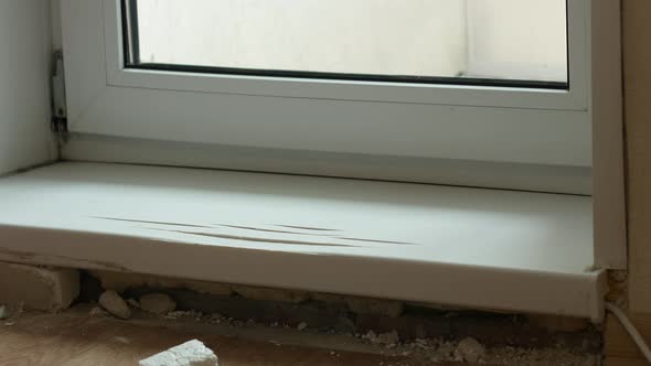 The master repairs a broken balcony plastic threshold in the apartment. Repair in the house, replace alt