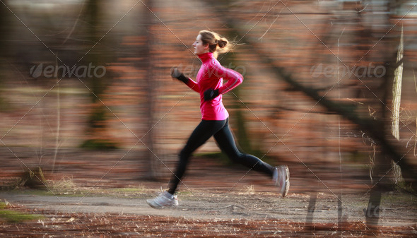 Young woman running outdoors in a city park on a cold fall/winte - Stock Photo - Images