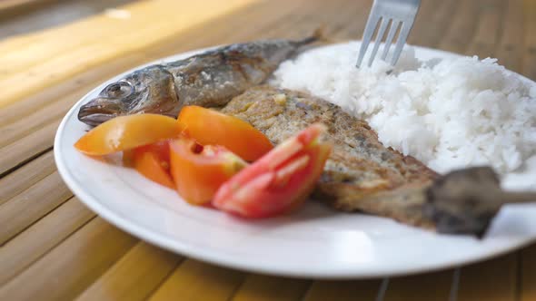 A Plate of Food Delicious Fried Fish with White Rice and Fresh Tomatoes