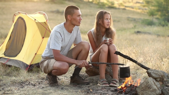 Couple At The Camping With Campfire