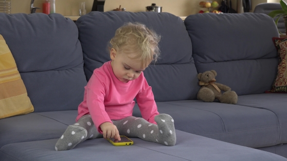 Hysterical Baby Girl Cry Using Smart Phone On Sofa.