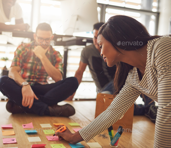 Woman writing on notes for workers on floor - Stock Photo - Images