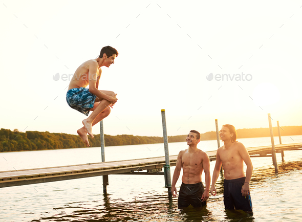 Teenage boy jumping into a lake - Stock Photo - Images