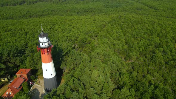The drone slow pulls out and reveals Stilo Lighthouse and green forest around it - lighthouse locate alt