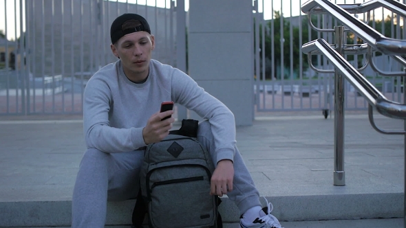 Young Fitness Man Talks On The Phone In The City 