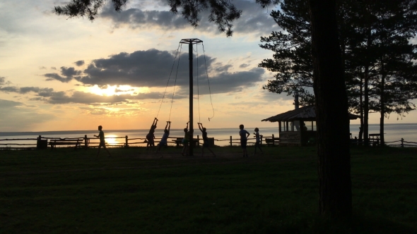 Children At Sunset Ride On a Swing