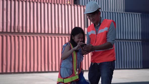 Father and daughter visiting cargo containers site, Father and daughter using smartphone