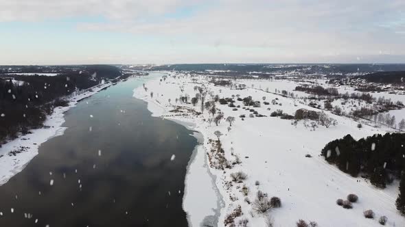 Winter wonderland and Nemunas river during snowfall, aerial drone view alt