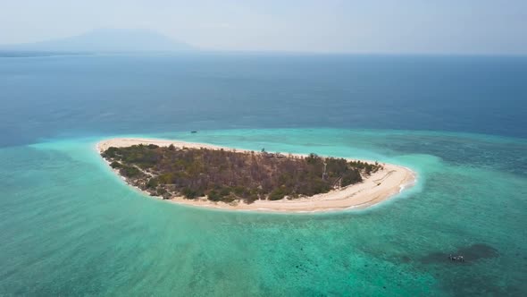 Drone shot orbiting around the remote Java Island of Tabuhan near Bali Indonesia alt