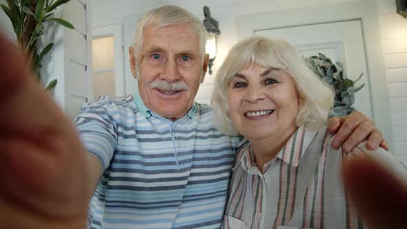 Senior Elderly Caucasian Couple Using Mobile Phone for Video Call, Making Selfie in Porch at Home alt