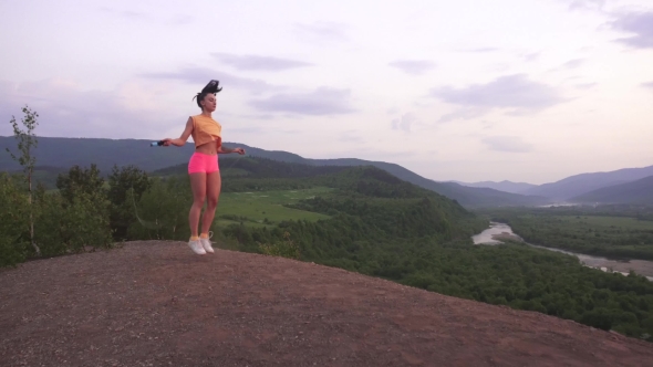 Active Young Brunette Woman Jumping With Skipping Rope On The Mountain Peak.