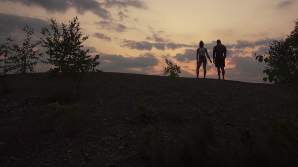 Silhouettes Of Fitness Muscular Mixed Race Couple Watching The Sunrise In Mountains