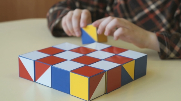 Boy Collecting a Pattern Using Colored Cubes