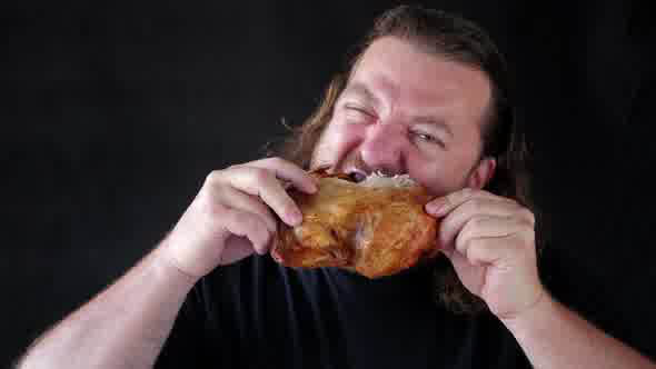 Man Biting With Relish A Piece Of Grill Chicken