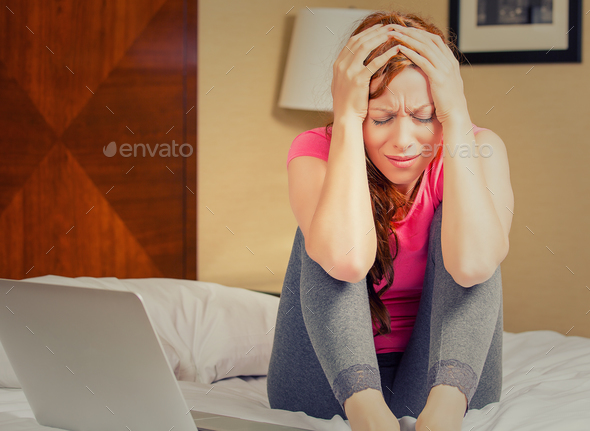 portrait stressed sad young woman sitting on bed looking desperate