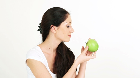 Young Attractive Woman Playing With And Offering Green Apple