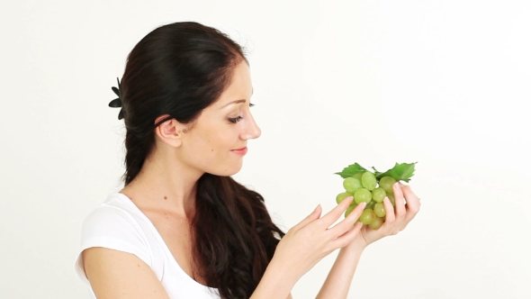 Young Attractive Woman Playing With And Offering Green Grape Cluster