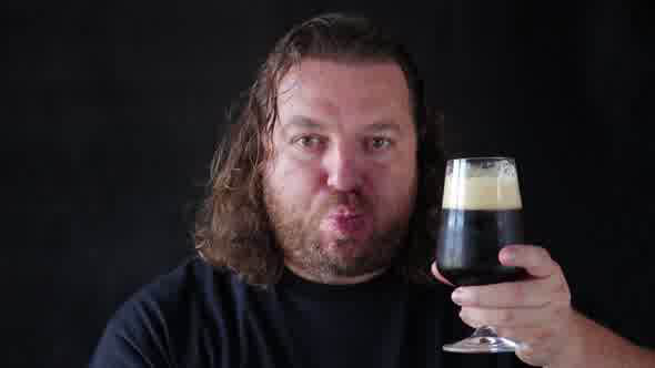 Man Drinking A Dark Beer