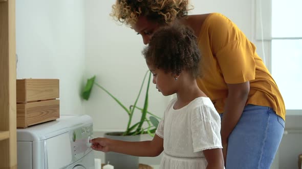 American Woman and Laundry Wash Machine Cloth Teach and Tell Young Daughter How to Start Washing alt