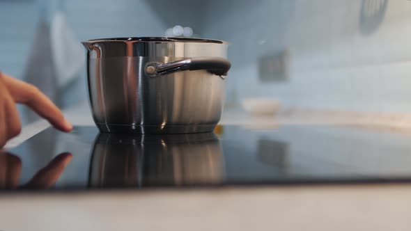 Man Prepares Pan on the Ceramic Hob alt