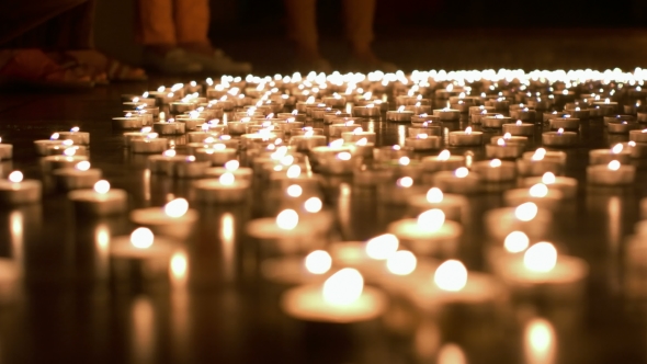 One Person Placing Candle To The Group Of Candles