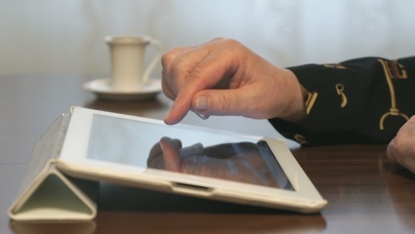 Woman's Hand Touches Screen Of a Digital Tablet