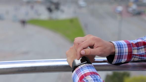 Man in the City Using Smart Watches 