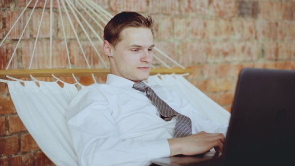 Happy Businessman In a Tie Relaxing On The Hammock