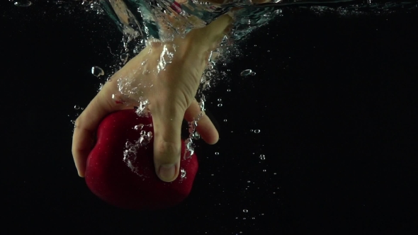 Man Hand Reaches And Grabs Red Apple Floating Under Water Super  Shot alt