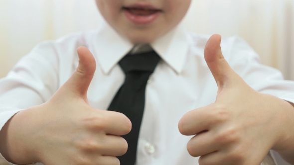 A Child Shows a Figure In The Form Of Thumb Up