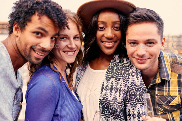 Multi-ethnic millenial group of friends taking a selfie on rooftop patio - Stock Photo - Images