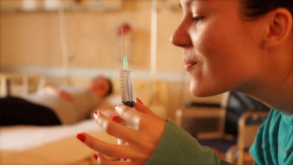 Nurse Holding a Needle at Hospital