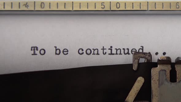 Typing phrase To be continued on retro typewriter. Close up. alt